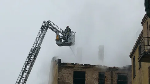 Firefighter on turntable ladder fighting fire 動画素材 99401664