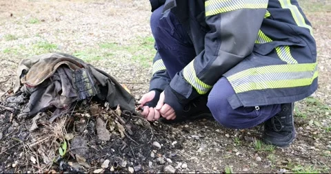 A firefighter in uniform expertly and safely building a campfire Stock Footage 321055212