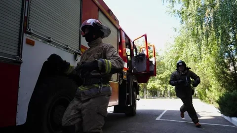 Firefighter in uniform opening shutter door of the big red truck with equipments Stock Footage 275492713