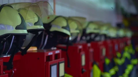 Firefighter uniforms hanging in row in fire station Stock Footage 120613160