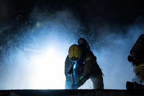 Firefighter using axe on roof Stock Photos