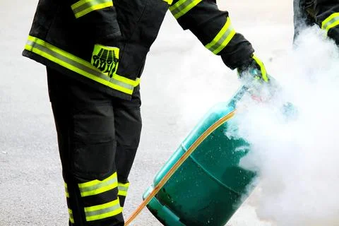 Firefighter using extinguisher and a foam cylinder to fire fighting Stock Photos