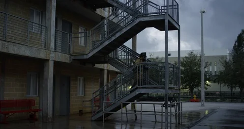 Firefighter walking up a staircase at dusk Stock Footage 107626835