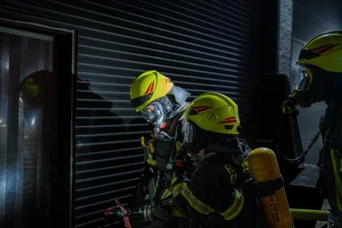 Firefighter walkint into a hall Stock Photos
