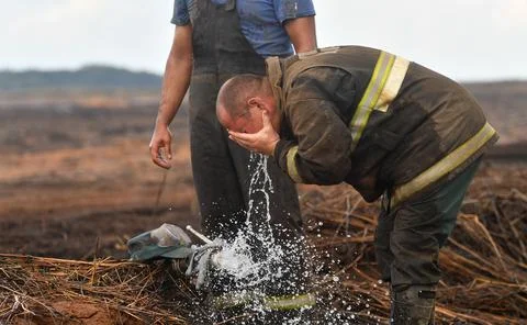 A firefighter washes his face Stock Photos