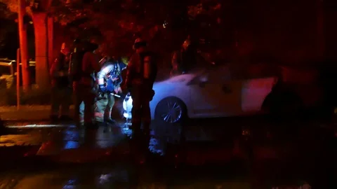 Firefighter working on the hood of a car fire with honk Stock Footage 99875335