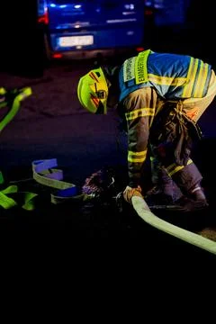 Firefighter working on a water distributor Stock Photos