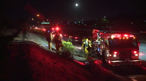 Firefighters and Firetrucks working on the side of the freeway at night Video stock 40822827