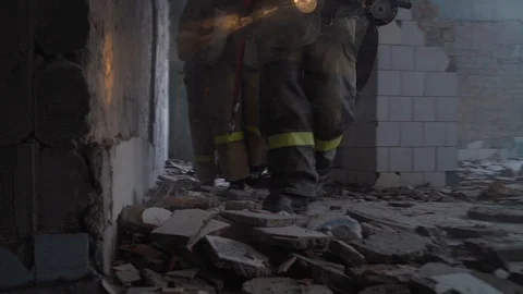 Firefighters are gingerly making their way in the smoke-filled room. Stock Footage 108457980