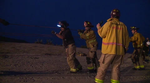 Firefighters attempt a night time Cliff Rescue and pull a rope together Video stock 40823359