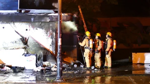 Firefighters on the back of a burned building Stock Footage 116012771