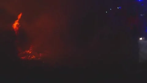 Firefighters battle a massive forest fire at night with water streams, with.. Stock Footage 316522835