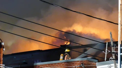 Firefighters battling fire at night Stock Footage 115932473