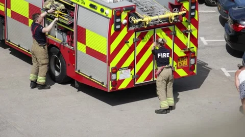 Firefighters closing rear doors on fire engine while packing equipment after Stock Footage 340123215