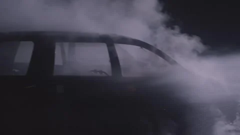 Firefighters combating a fire on a burned car accident at night with water hose Stock Footage 272763313