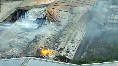 A firefighters combating a large industrial fire. Stock Footage 313468271
