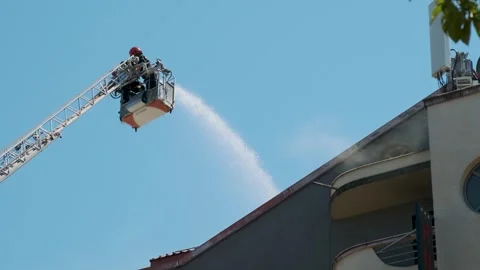 Firefighters in elevated platform extinguish burning house using extended ladder Stock Footage 282380919