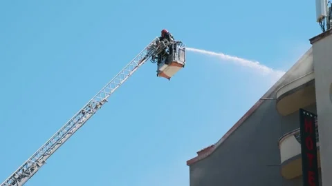 Firefighters in elevated platform extinguish burning house using extended ladder Stock Footage 282813261