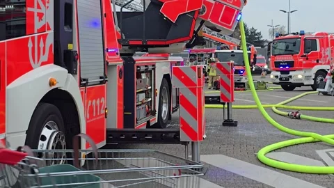 Firefighters at an emergency scene with fire trucks and equipment Stock Footage 331396243
