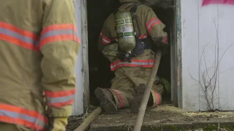 Firefighters enter a burning house Stock Footage 60795512