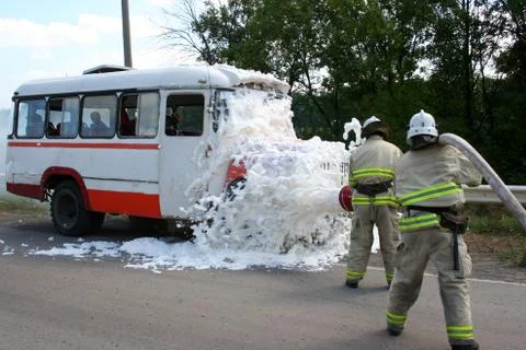 Firefighters  extinguish a burning bus Stock Photos