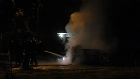 Firefighters extinguish a burning car Stock Footage 146859488