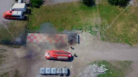 Firefighters extinguish burning garbage can, aerial Stock Footage 95449085