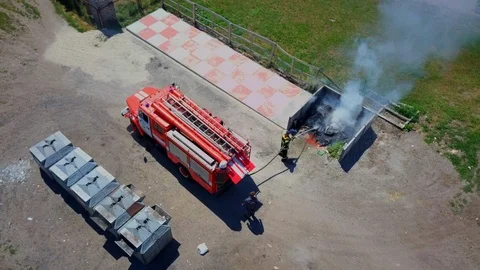 Firefighters extinguish burning garbage can, aerial Stock Footage 95449635