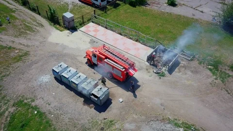 Firefighters extinguish burning garbage can, aerial Stock Footage 95449965