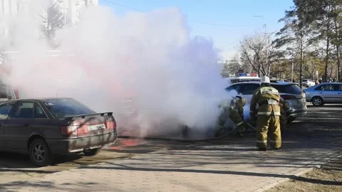Firefighters extinguish car fire outside. lot of thick white smoke, burning car Stock Footage 283889772