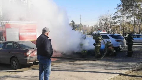 Firefighters extinguish car fire outside. male eyewitness films incident Stock Footage 284245470