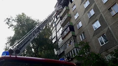 Firefighters extinguish a fire on the balcony of a high-rise building in th.. Stock Footage 257054853