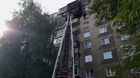 Firefighters extinguish a fire on the balcony of a high-rise building in th.. Stock Footage 257429503