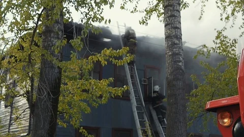 Firefighters extinguish the fire. Burning old abandoned house. Slow Motion Vi Stock Footage 102589013
