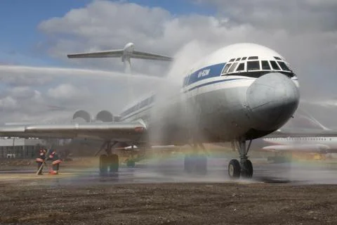 Firefighters extinguish a fire engine from the plane on a background of rainbow Stock Photos