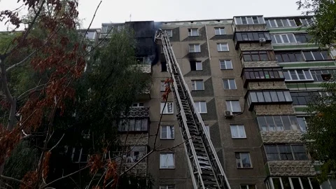 Firefighters extinguish a fire while on a fire escape on the balcony of a m.. Stock Footage 255103306