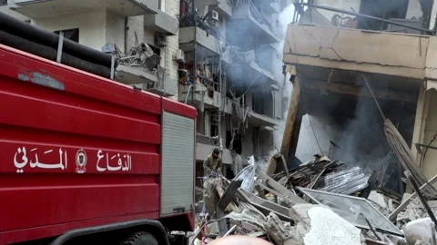 Firefighters extinguish fires in the rubbles after Israeli airstrikes on Beirut Stock Footage 294430311