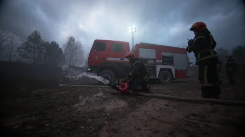 Firefighters extinguishing fire with water Stock Footage 283182762