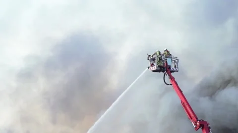 Firefighters fighting fire from above on a platform Stock Footage 131672138