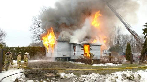 Firefighters fighting flames at house fire during day Video stock 112021479
