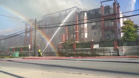 Firefighters fighting with flames to put them out and rainbow comes out. Stock Footage 135435098