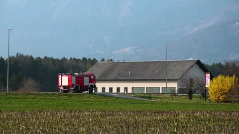 Firefighters firemen and fire trucks passing by on countryside road Stock Footage 188699881