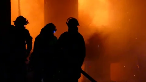 Firefighters Fixing Hose While Battling House Fire During Night Stock Footage 76758286