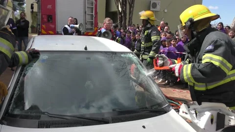 Firefighters forcefully removing window windshield of car after accident Видео 135362231