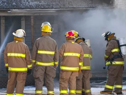 Firefighters in front of disaster Stock Photos