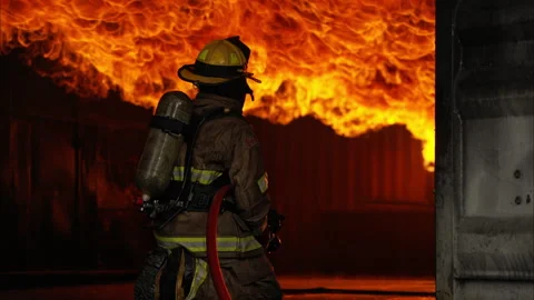 A firefighters in full protective gear work to extinguish a massive blaze Vídeos de archivo 326218361
