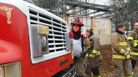 Firefighters in gear waiting for assignment at the front of fire truck Stock Footage 59523061
