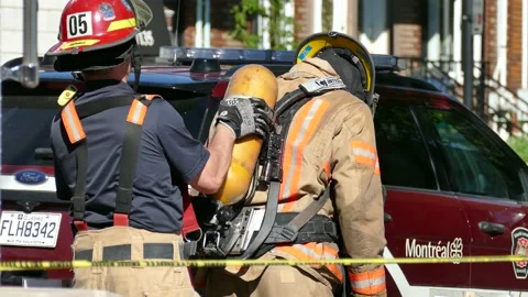Firefighters getting oxygen tank out of the back of a firefighter Stock Footage 139664488