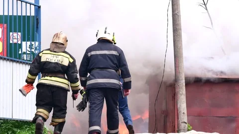 Firefighters go in the direction of the burning building. Stock Footage 109388731