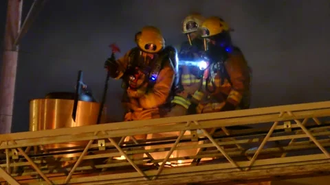 Firefighters with heavy flames at night Stock Footage 139663813